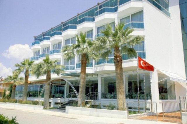 a building with palm trees in front of it at Idahan Hotel in Burhaniye