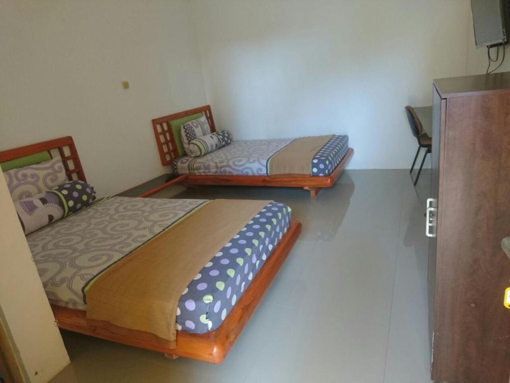 two twin beds in a room withthritisthritisthritisthritisthritisthritisthritisthritisthritis at Cerah Hotel in Paiton