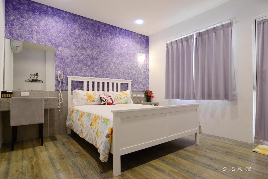 ein Schlafzimmer mit einem weißen Bett und einer lila Wand in der Unterkunft OS Homestay in Nanwan