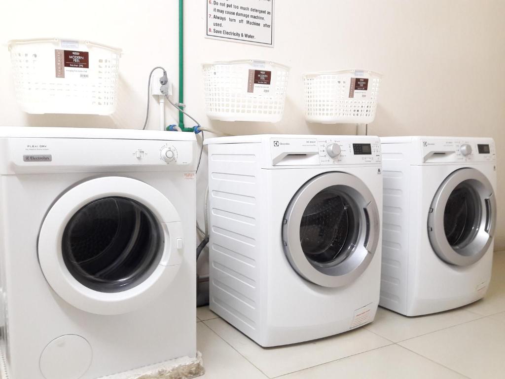 two washing machines and a washer and dryer in a room at Bluesky Serviced Apartment Airport Plaza in Ho Chi Minh City