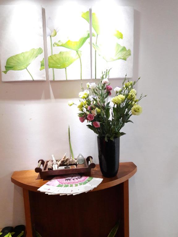 a vase of flowers sitting on top of a table at Bluesky Serviced Apartment Airport Plaza in Ho Chi Minh City