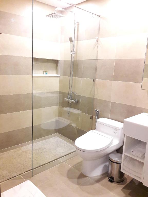 a bathroom with a toilet and a glass shower at Bluesky Serviced Apartment Airport Plaza in Ho Chi Minh City