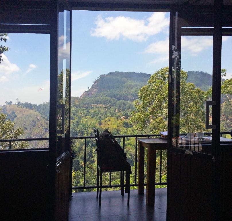 Cette chambre dispose d'une table et offre une vue sur la montagne. dans l'établissement Cloudy Hill Cottage, à Ella