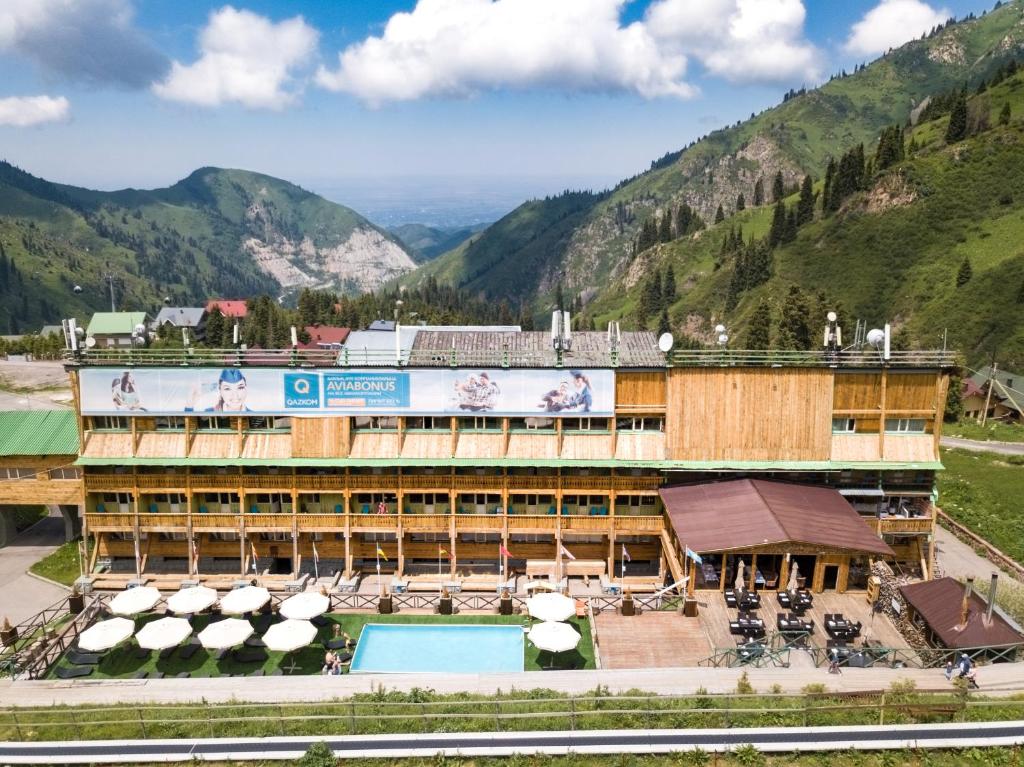 a resort with a swimming pool and mountains in the background at Shymbulak Resort Hotel in Almaty