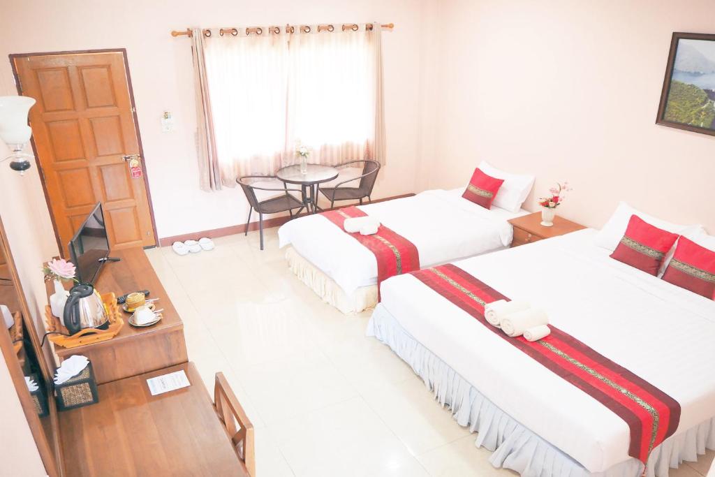 Ban Lai Ngao的住宿－康柯麗德度假酒店，酒店客房设有两张床和一张桌子。