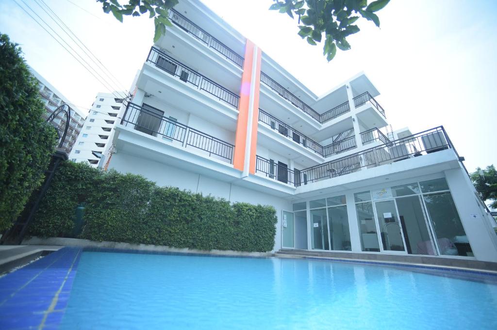 a building with a swimming pool in front of it at Villa Navin Beach Residence in Jomtien Beach