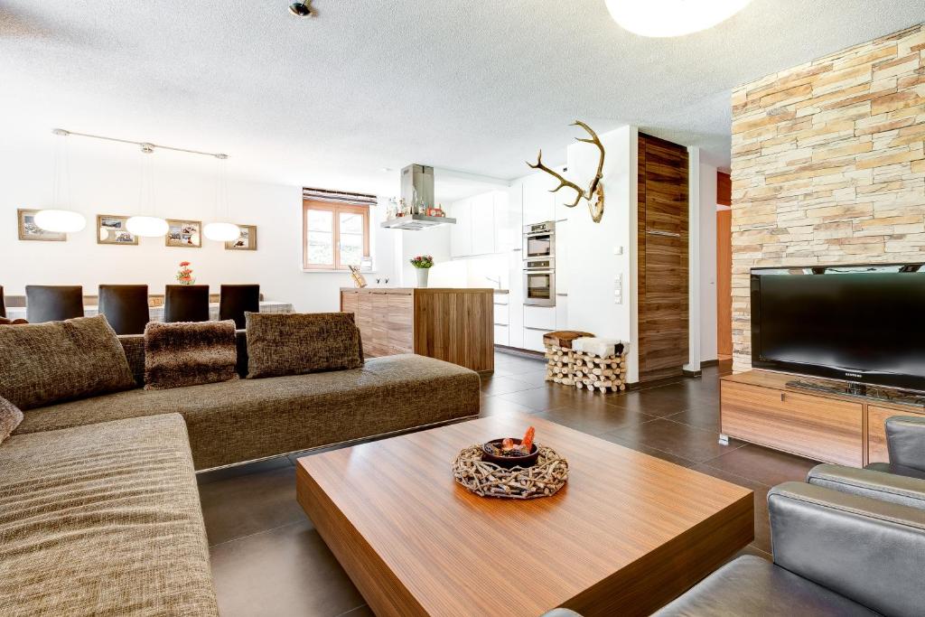 a living room with a couch and a tv at Gartenferienwohnung Ski In by A-Appartments in Brand