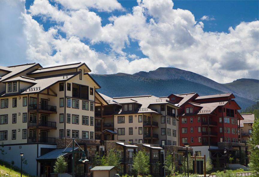 a group of buildings with mountains in the background at Fraser Crossing and Founders Pointe in Winter Park