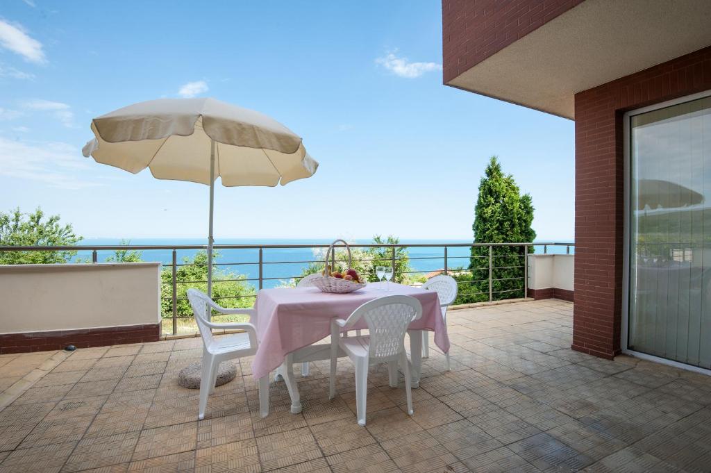 a table and chairs on a patio with an umbrella at Momchil Villas in Balchik