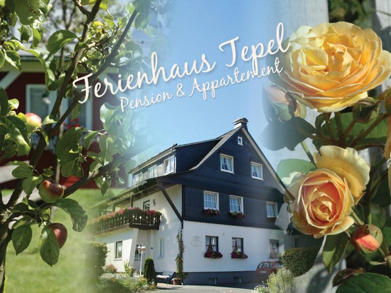 una foto di una casa con delle rose davanti di Gästehaus Tepel a Winterberg
