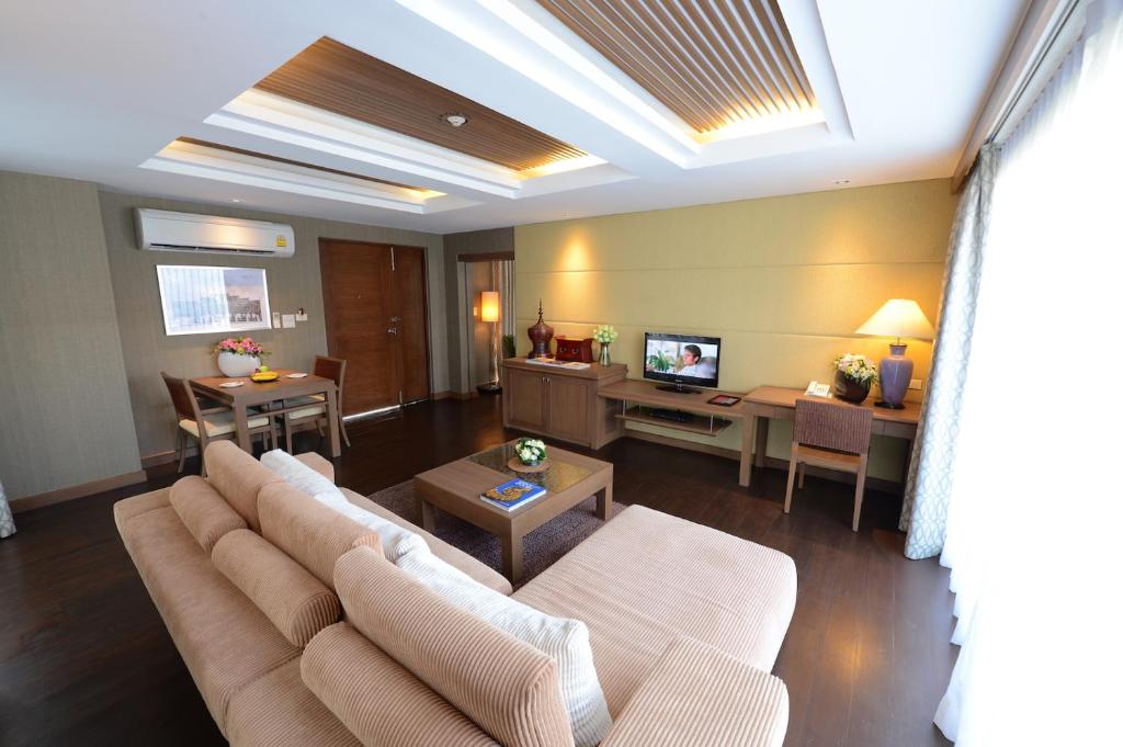 A separate sitting room with a large sofa, coffee table, television, desk, and dining table.