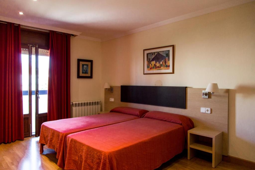 a bedroom with a red bed with a red blanket at Hostal Casa Manolo in La Senia