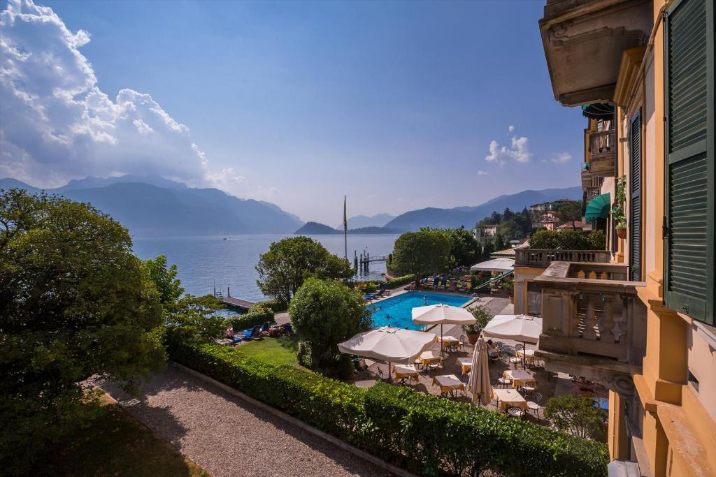 uma vista para um resort com uma piscina, cadeiras e guarda-sóis em Casa Daniele em Menaggio