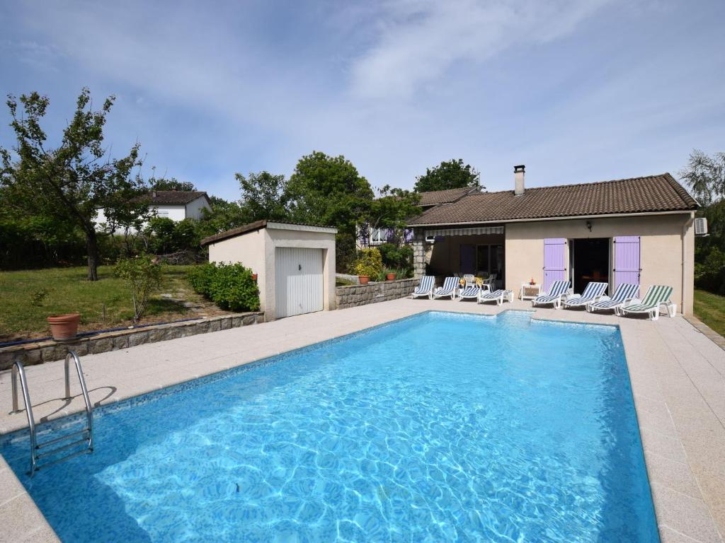 a swimming pool with chairs and a house at Detached villa in a small villa estate with private swimming pool in Ruoms