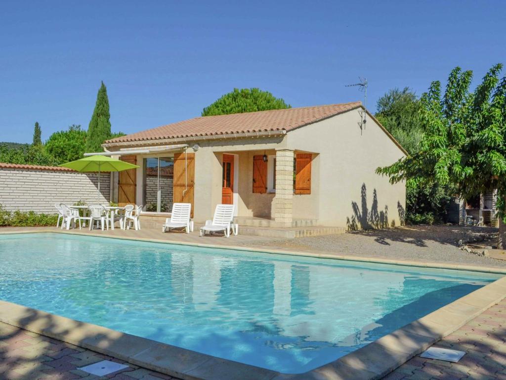 a house with a swimming pool in front of a house at Beautiful holiday home in Argeliers with pool in Argeliers