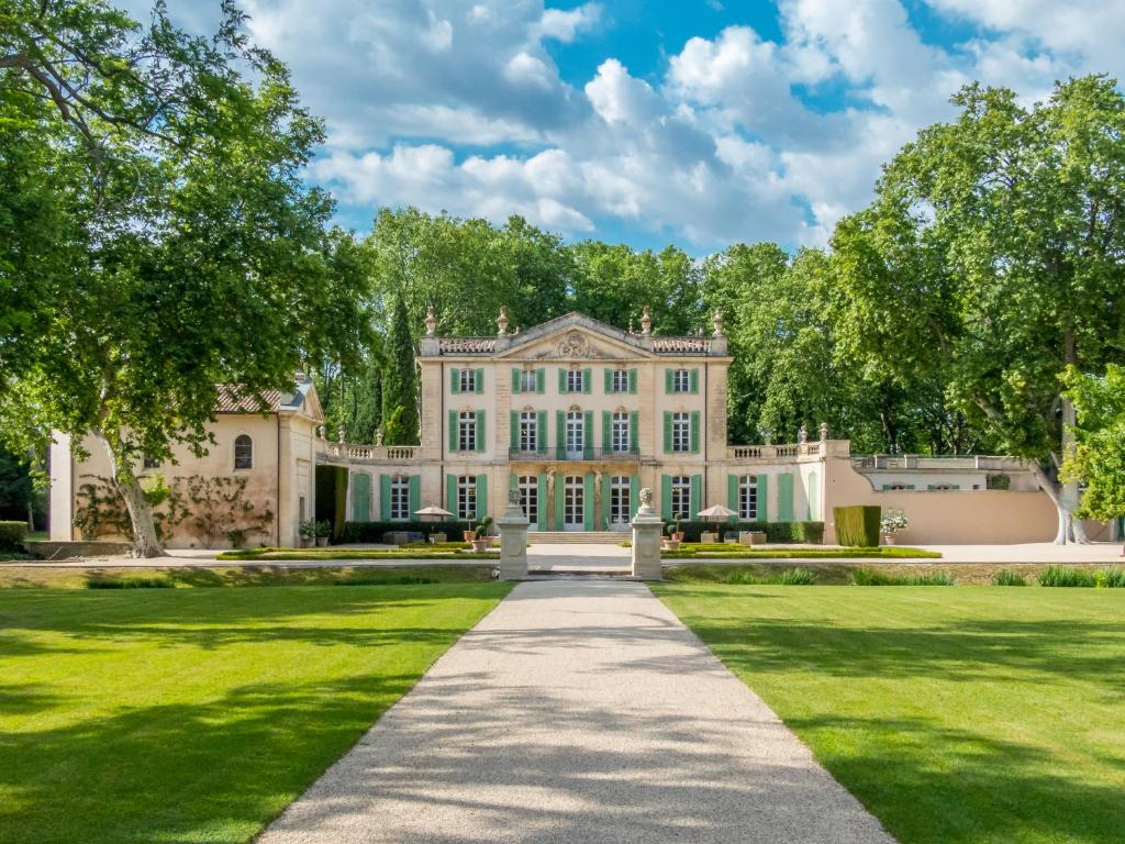 an exterior view of a large house with a lawn at Chateau de Tourreau in Sarrians