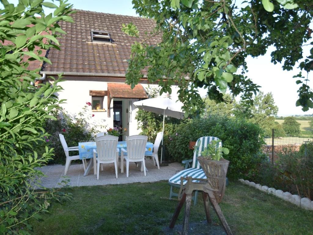 eine Terrasse mit einem Tisch, Stühlen und einem Sonnenschirm in der Unterkunft Peaceful holiday home with heated pool in Vignol