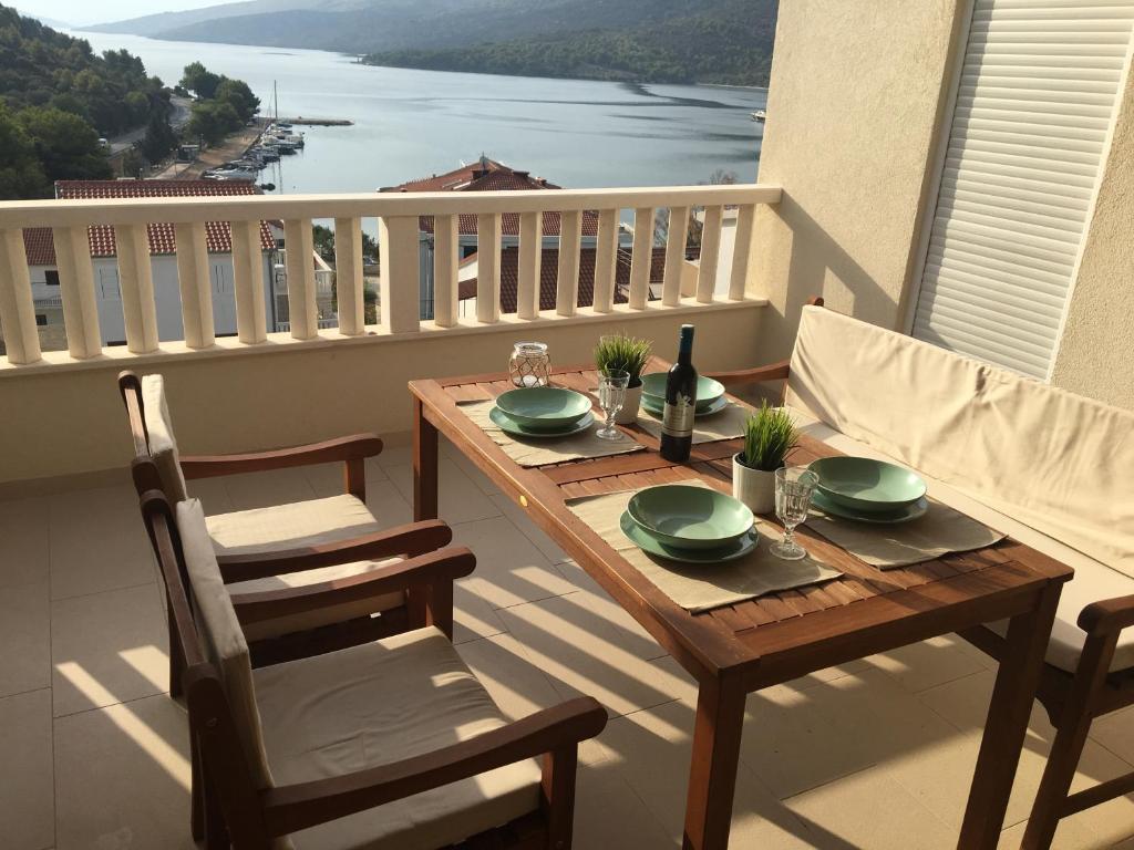 a wooden table and chairs on a balcony with a view at Mediterranean Apartment With Great Sea View in Marina