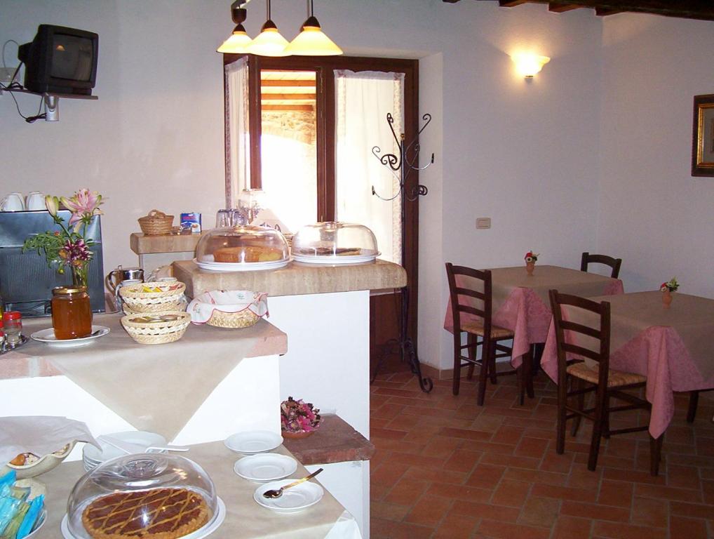 cocina y comedor con mesa y sillas en Agriturismo Il Poggiolo, en Montemerano