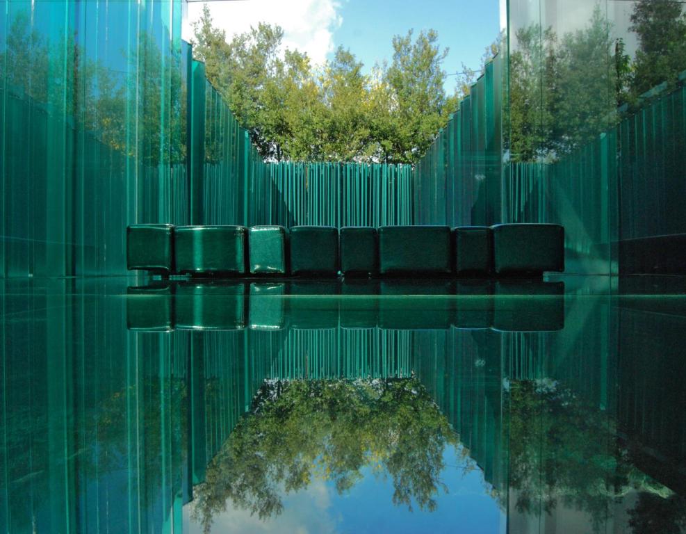 un reflejo de sillas en una piscina de agua en Les Cols Pavellons, en Olot