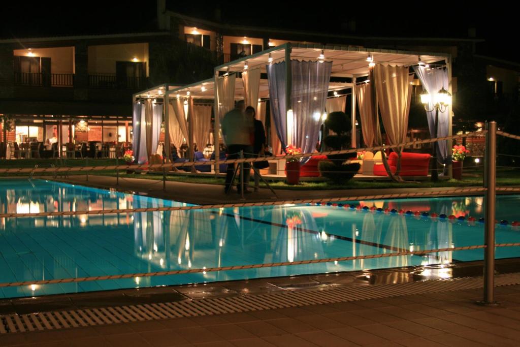 a swimming pool in front of a hotel at night at Le Chalet in Xanthi