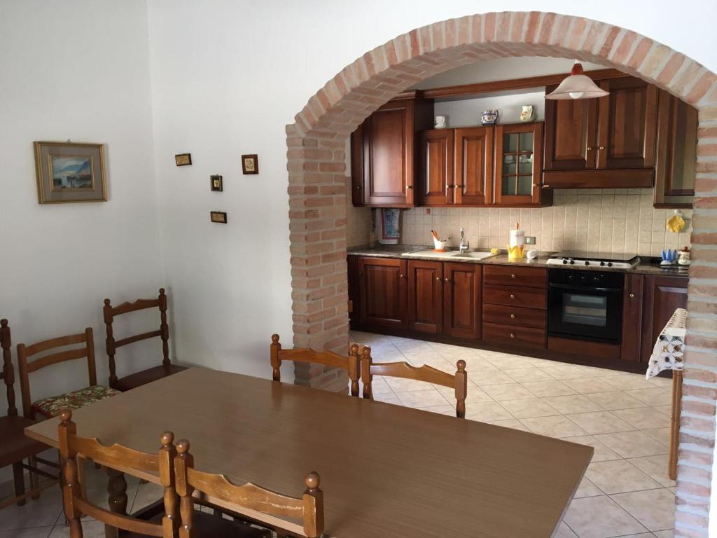 una cocina con una mesa de madera y un arco en Appartamento Biancospino, en Gualdo Tadino