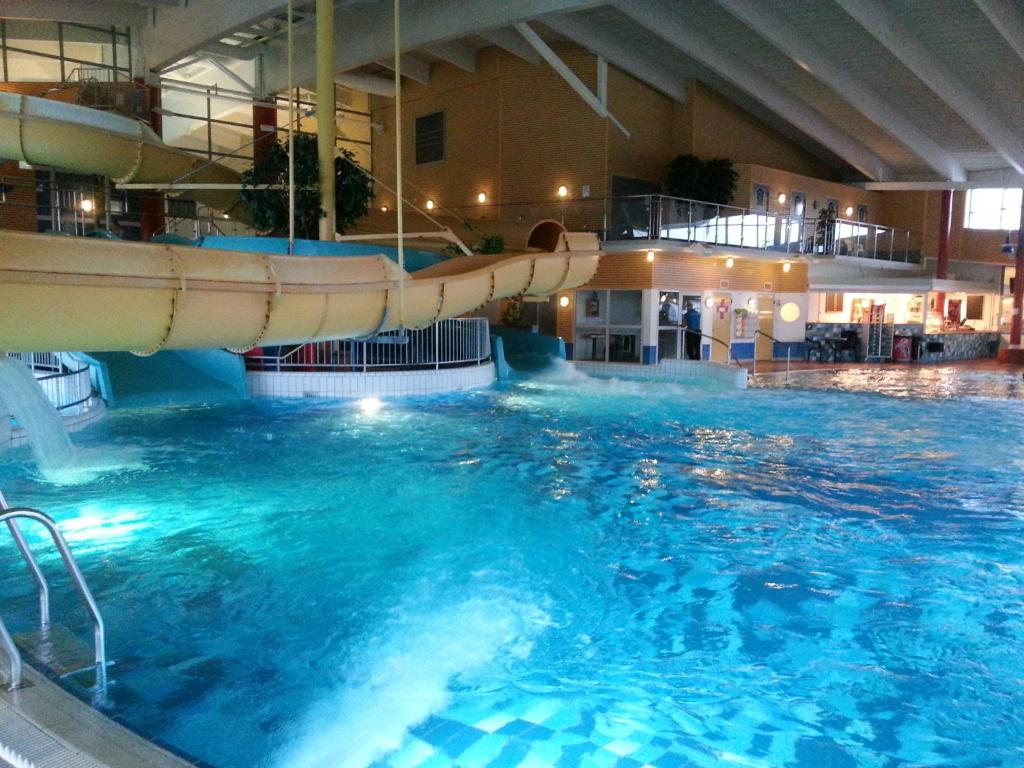 Corvin Rose Apartment Hotel في بودابست: مسبح بزحليقة مائية في مبنى