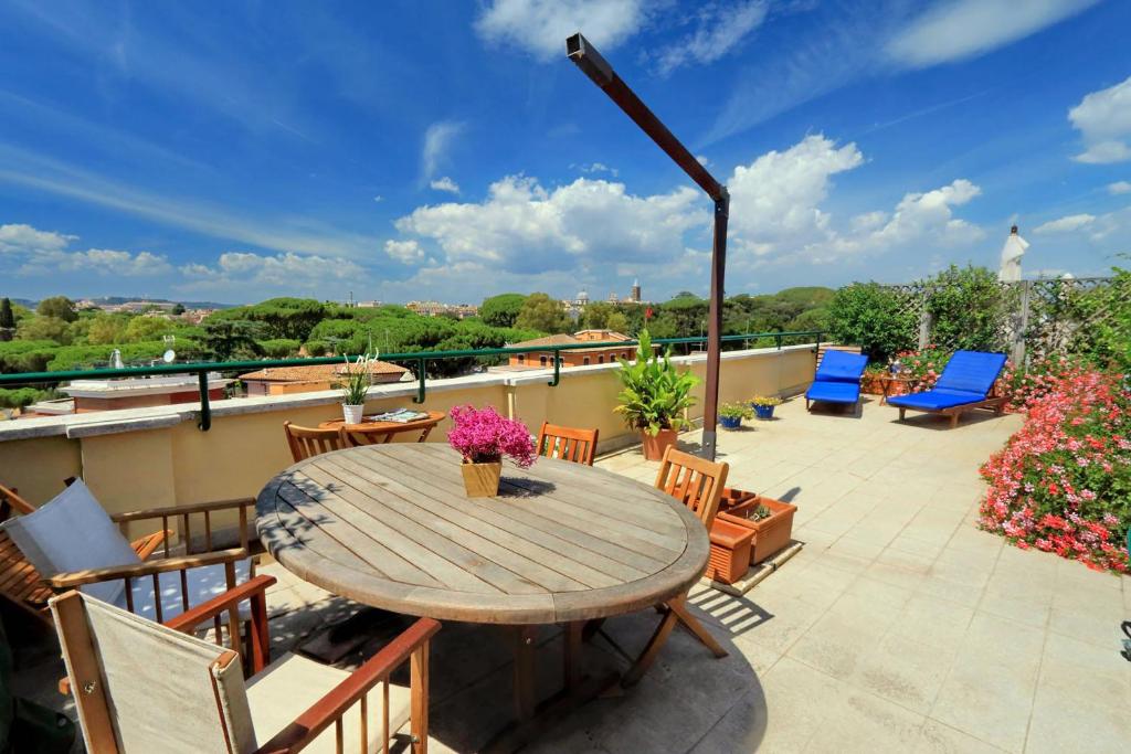 a patio with a wooden table and chairs at Mecenate Charme Apartment in Rome