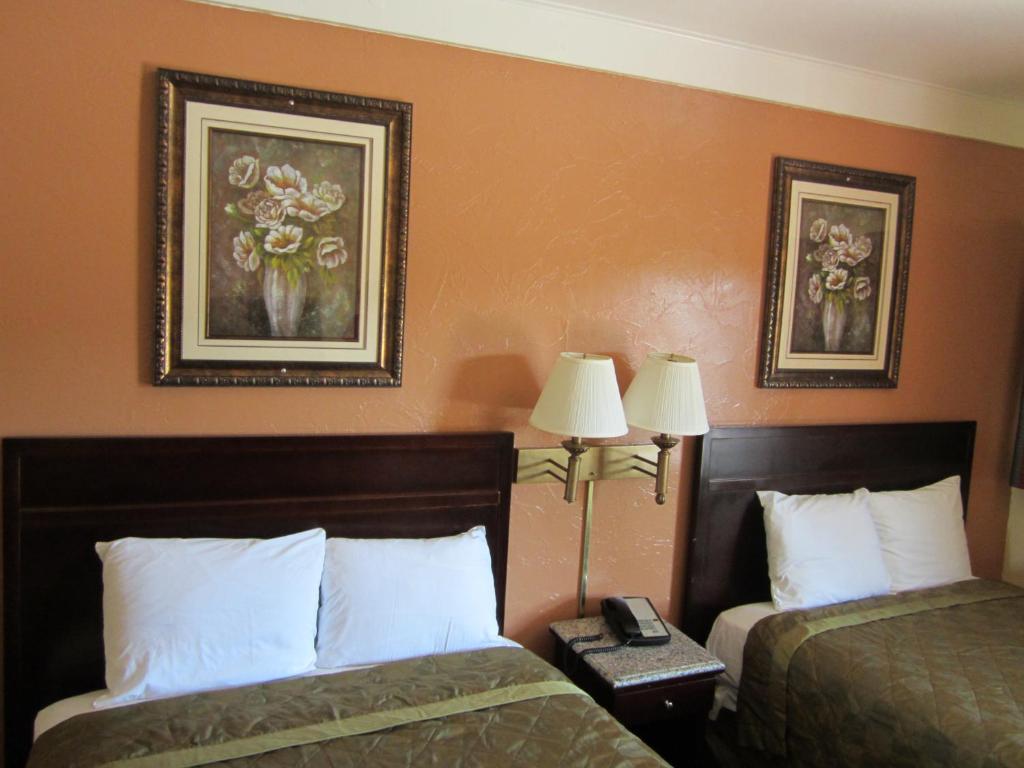 ein Hotelzimmer mit 2 Betten und 2 Lampen in der Unterkunft Civic Center Lodge / Lake Merritt BART in Oakland