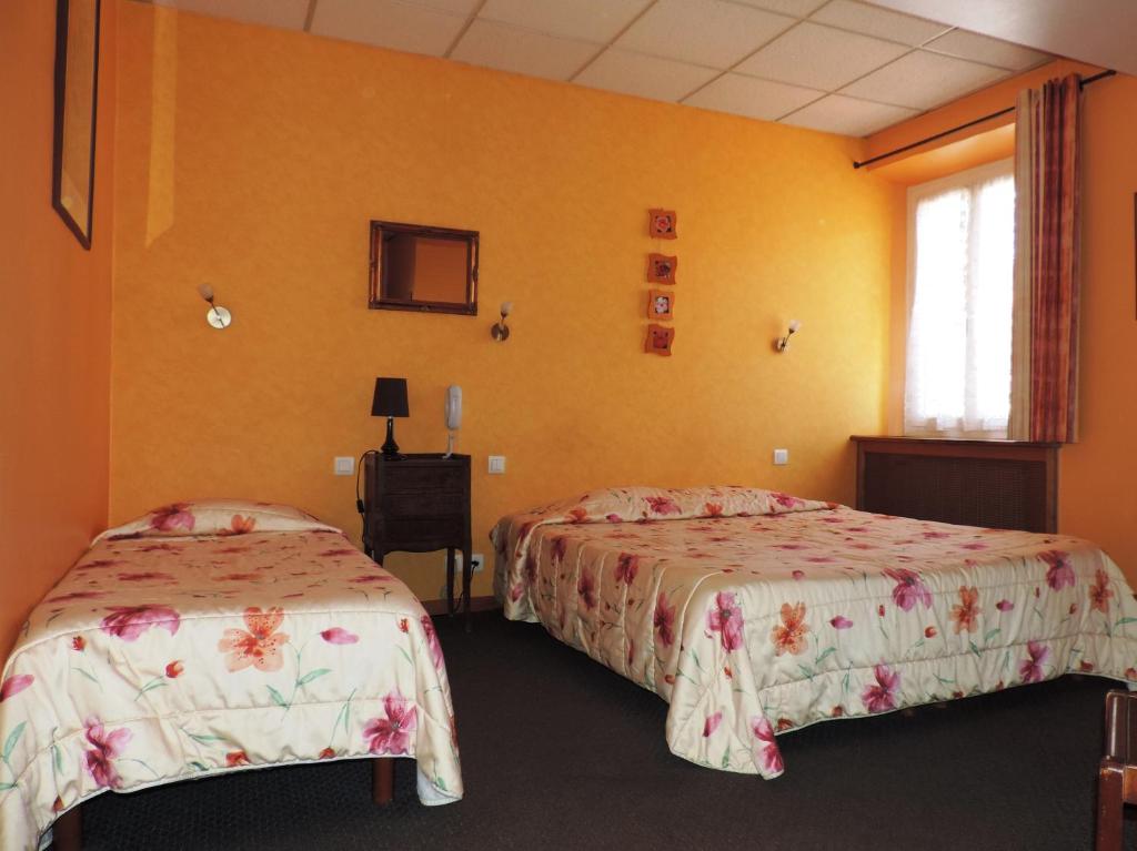 - 2 lits dans une chambre aux murs jaunes dans l&#39;établissement Hotel De Provence, à Digne-Les-Bains
