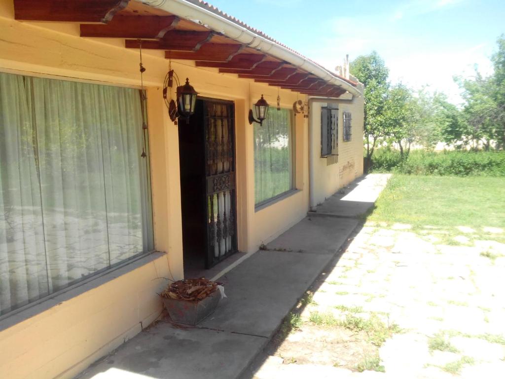 un porche de una casa con una puerta negra en Jardin Secreto Russell Maipu en Mendoza