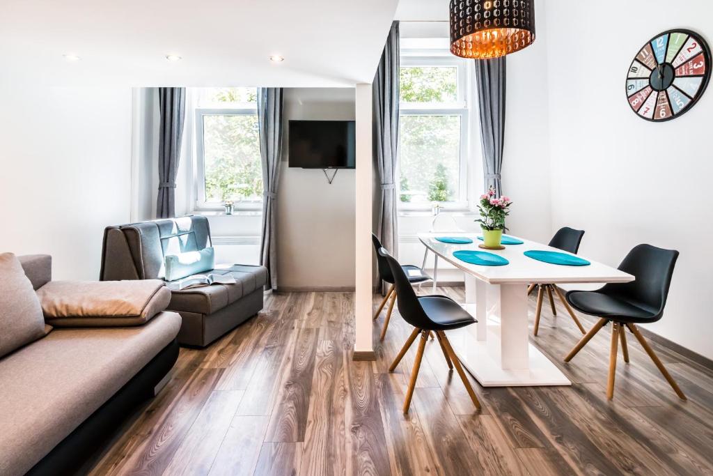 ブダペストにあるBpR Szondi Cozy Apartmentのリビングルーム(ソファ、テーブル、椅子付)