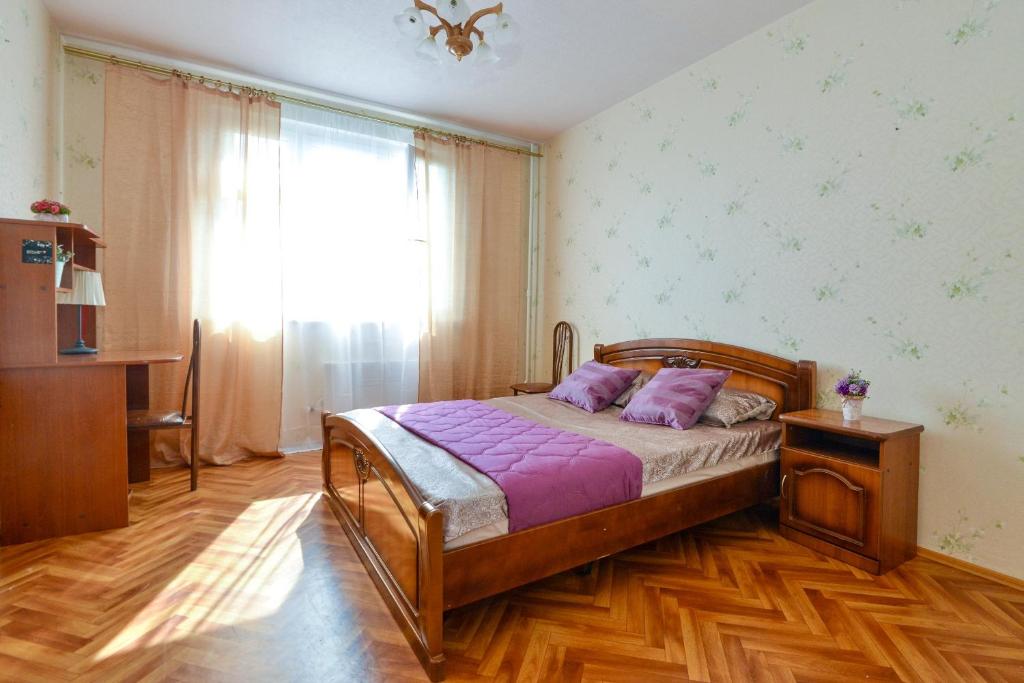 モスクワにあるApartamienty na Azovskoi 9k2のベッドルーム1室(紫のシーツが敷かれたベッド1台、窓付)