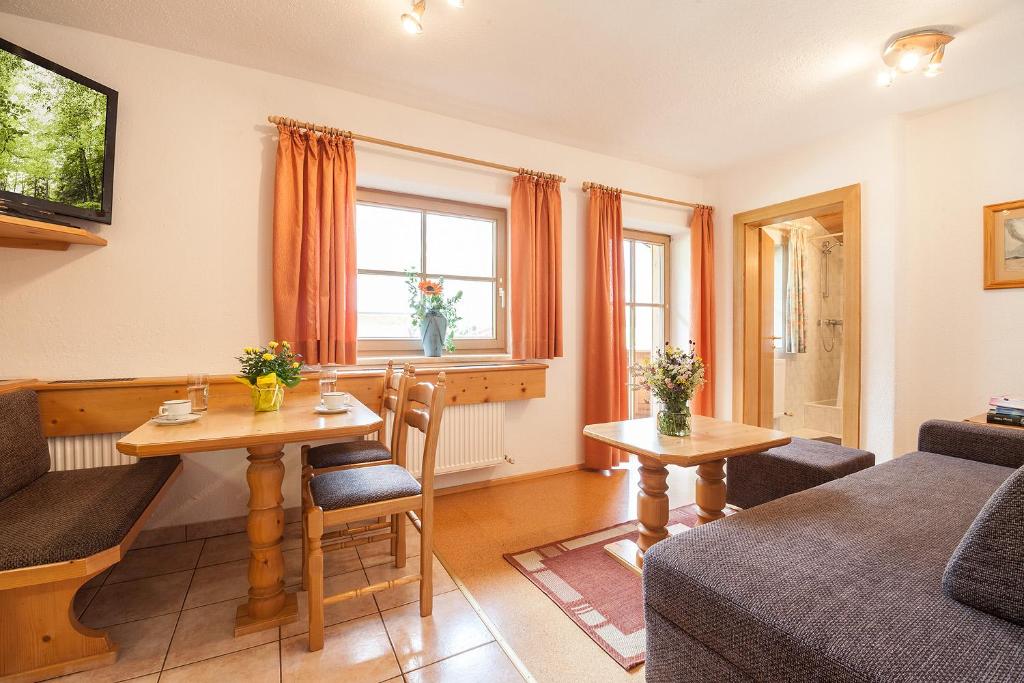 a living room with a couch and a table at Landhaus Lindl - Ein ruhiges Platzl zum Wohlfühlen in Leutasch