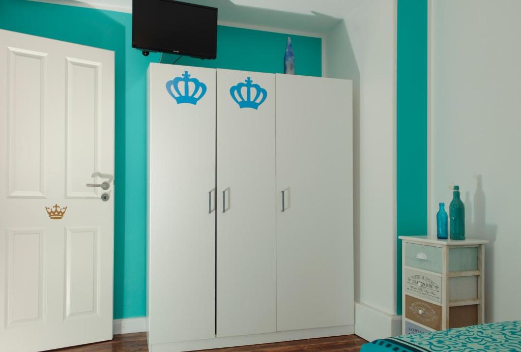 a room with two white wardrobes with crowns at Apartmenthaus Kornstrasse in Bremen