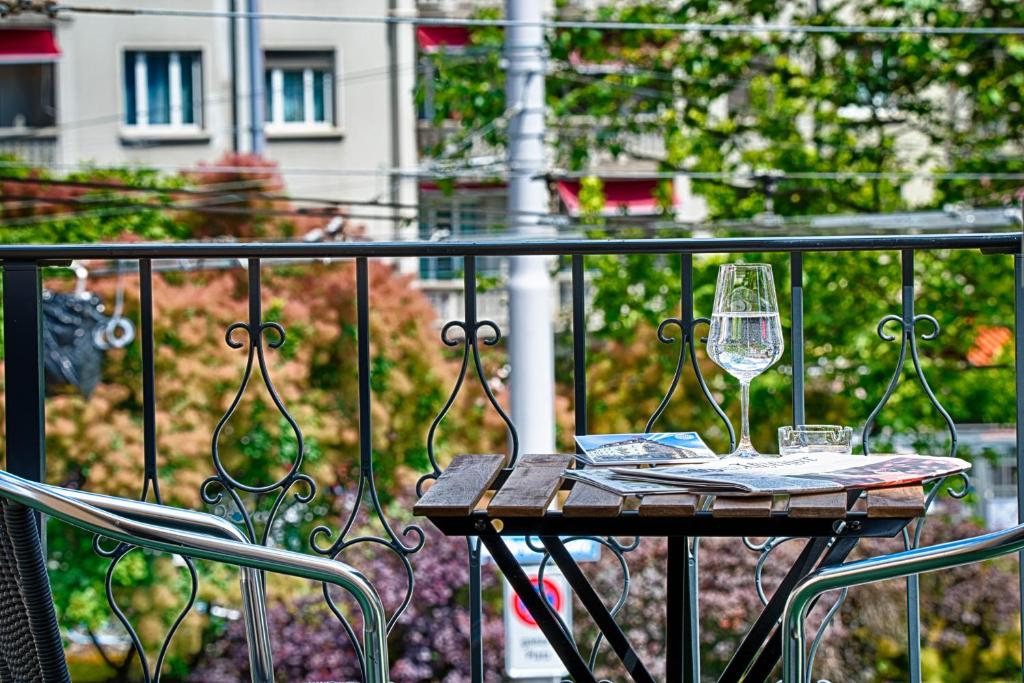 a table with two glasses of wine on a balcony at Hotel Neufeld in Zürich