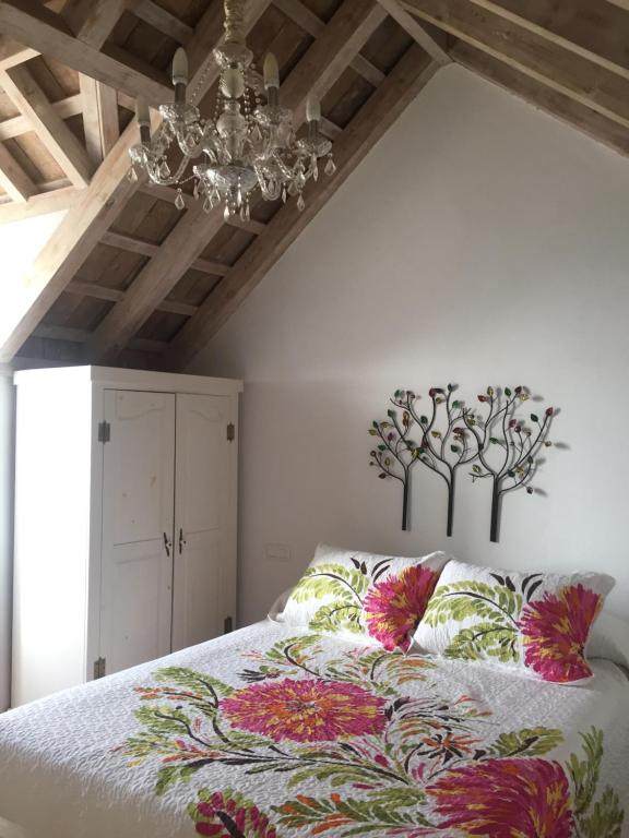 a bedroom with a bed with a chandelier at La Casa de Abu - Casita con Encanto in Medina Sidonia