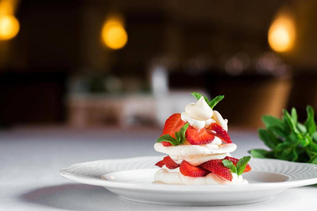 Layered meringue dessert topped with fresh strawberries and mint, delicate presentation
