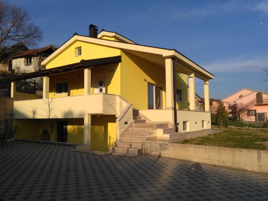 ein gelbes und weißes Haus mit einigen Treppen in der Unterkunft Holiday House Krizanovic in Domanovići