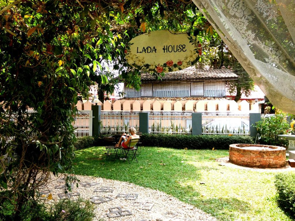 a person sitting in a chair in a yard at Lada House in Lampang