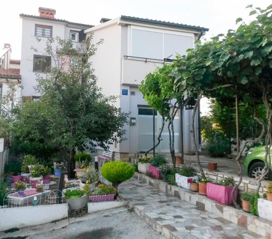 een tuin voor een huis met potplanten bij Apartments Žufić in Štinjan