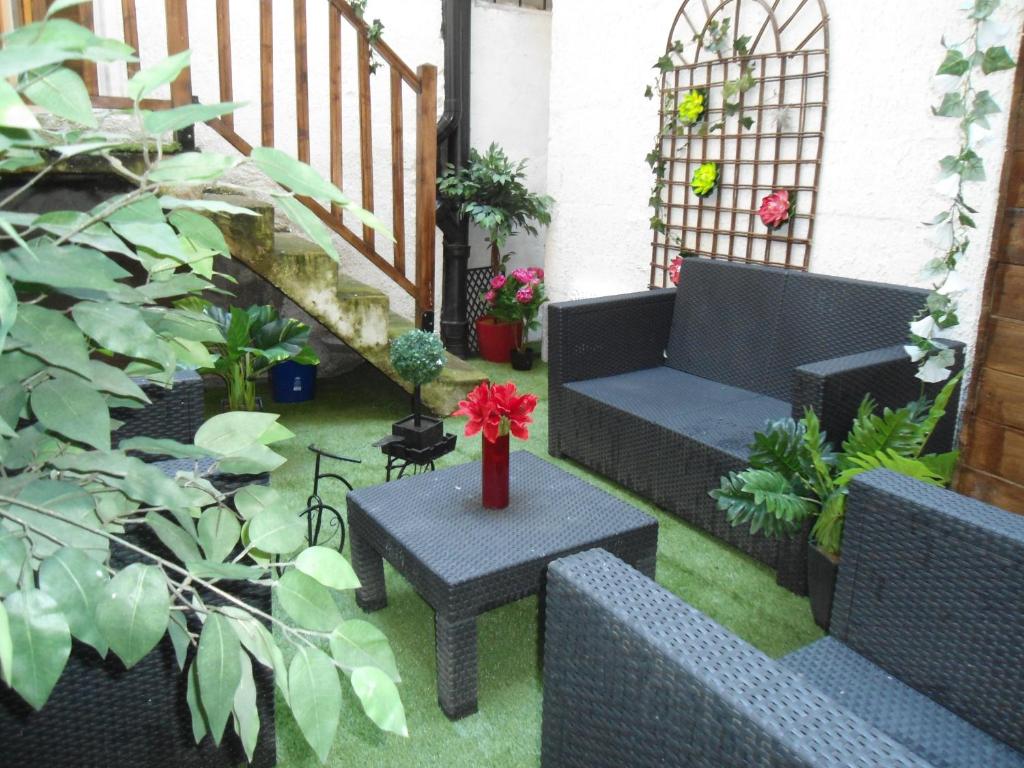 Appart Jardin en Ville Cœur de Nantes في نانت: فناء مع أريكة وطاولة ونباتات