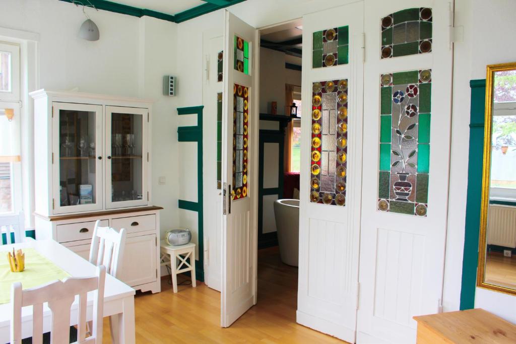 cocina y comedor con mesa y puerta en Ferienwohnung Villa Parkblick, en Oberhof