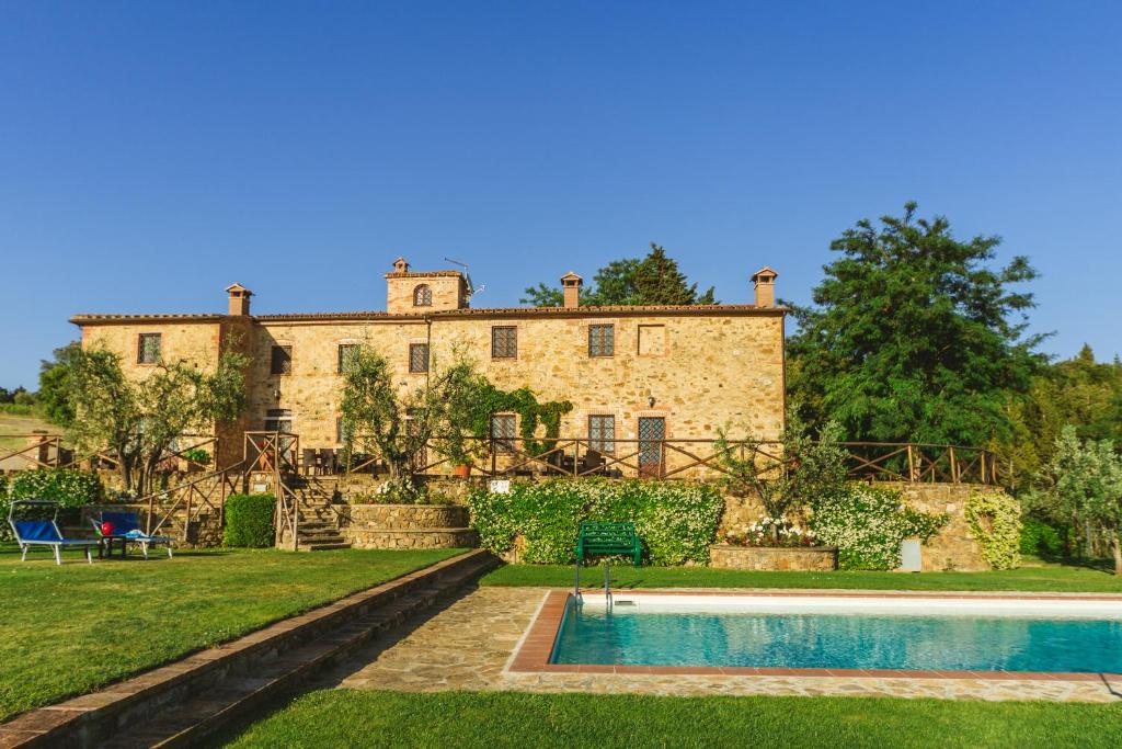 an estate with a swimming pool in front of a building at Ormanni nel Chianti Classico in Barberino di Val dʼElsa