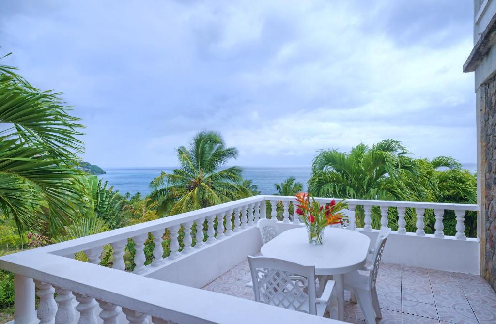 balcón con mesa, sillas y vistas al océano en Royal Palm Holiday Apartment, en Méro