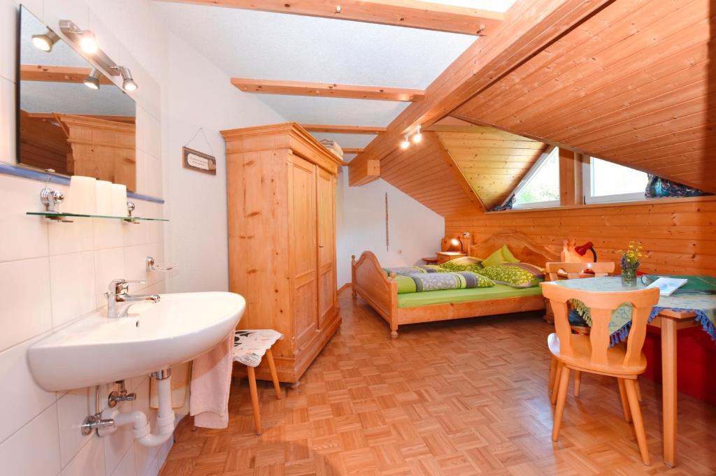 a bathroom with a sink and a couch in a room at Lindenhof in Sulzberg