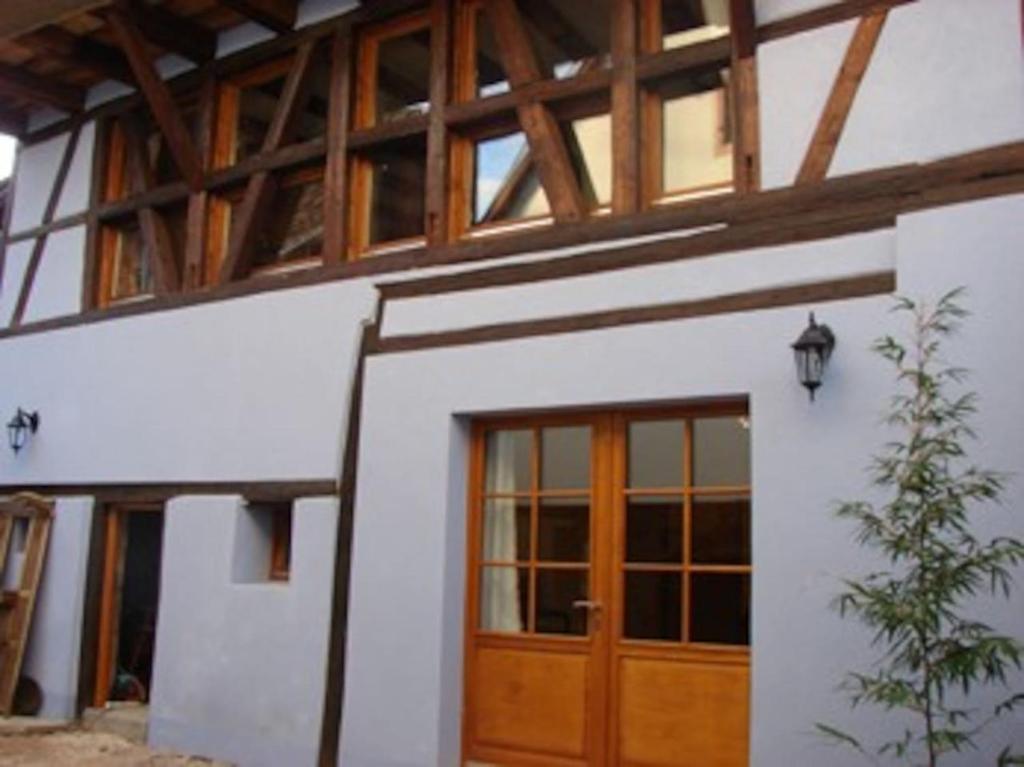 テュルクアイムにあるla grange de louisの木製のドアと窓のある家