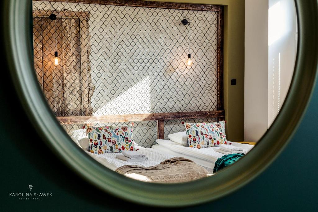 a reflection of a bedroom with two beds in a mirror at BOHO Apartments in Łódź