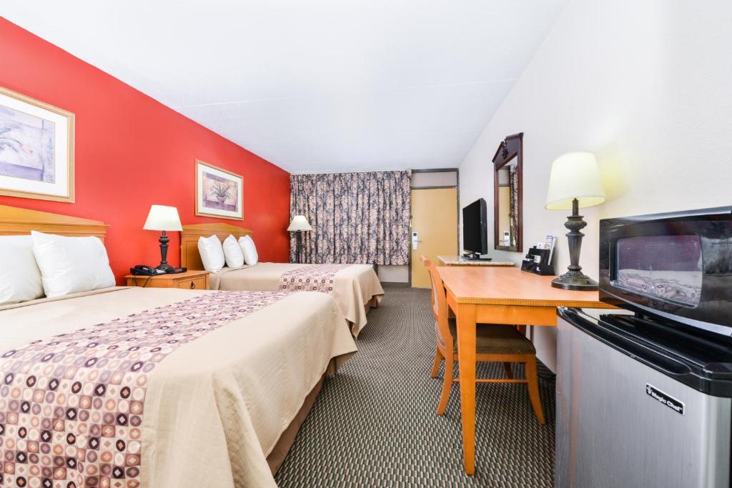 a hotel room with two beds and a flat screen tv at Americas Best Value Inn - Goodlettsville in Goodlettsville