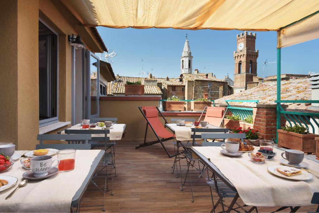 a balcony with tables and chairs with a view of the city at La Bellavita B&B in Pienza